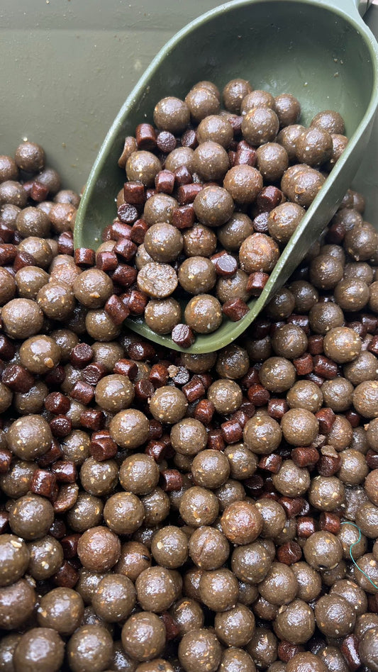 Boilies and pellets coated with carp fishing oil before being introduced into a baited area.