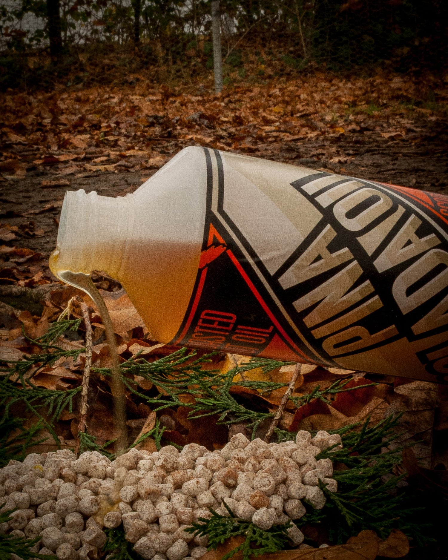 max attract baits pinacolada oil being poured onto pellets with a brown leafy back ground