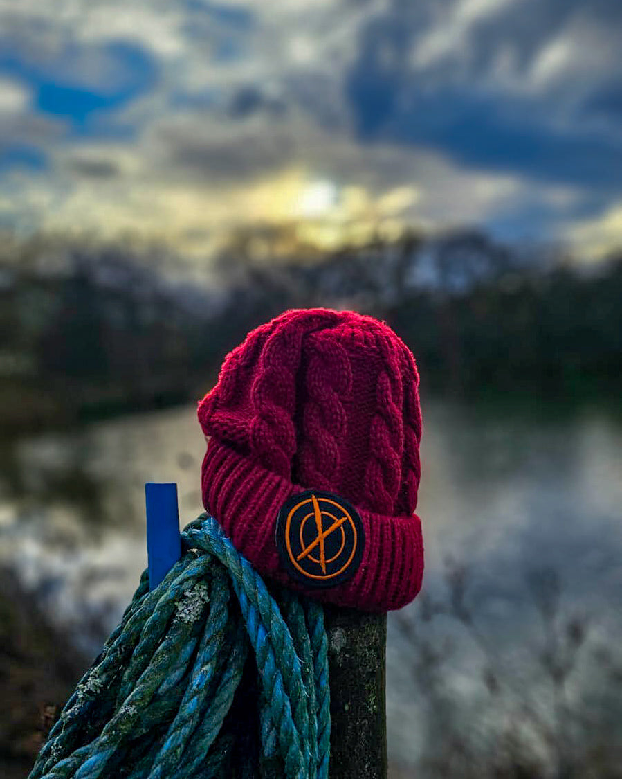 red max attract baits bobble hat on a fence post which has blue rope wrapped around it, over looking carp lake