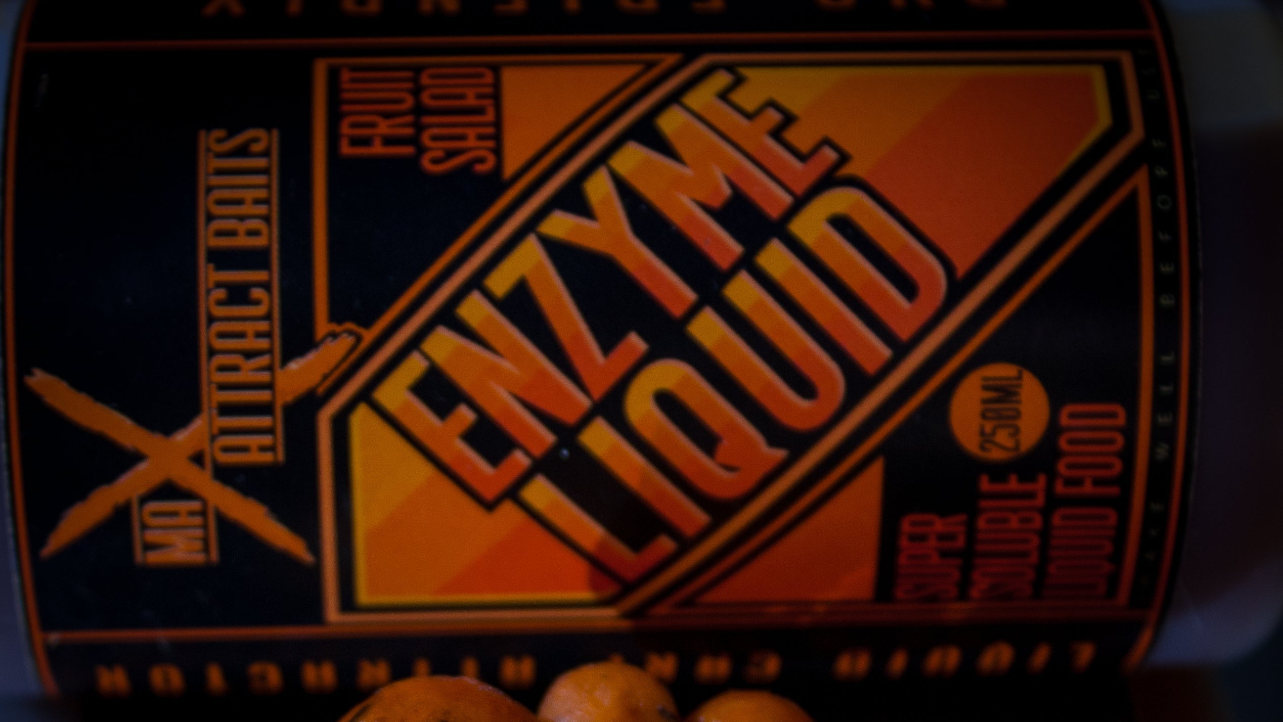 Enzyme liquid product with orange balls on a dark background