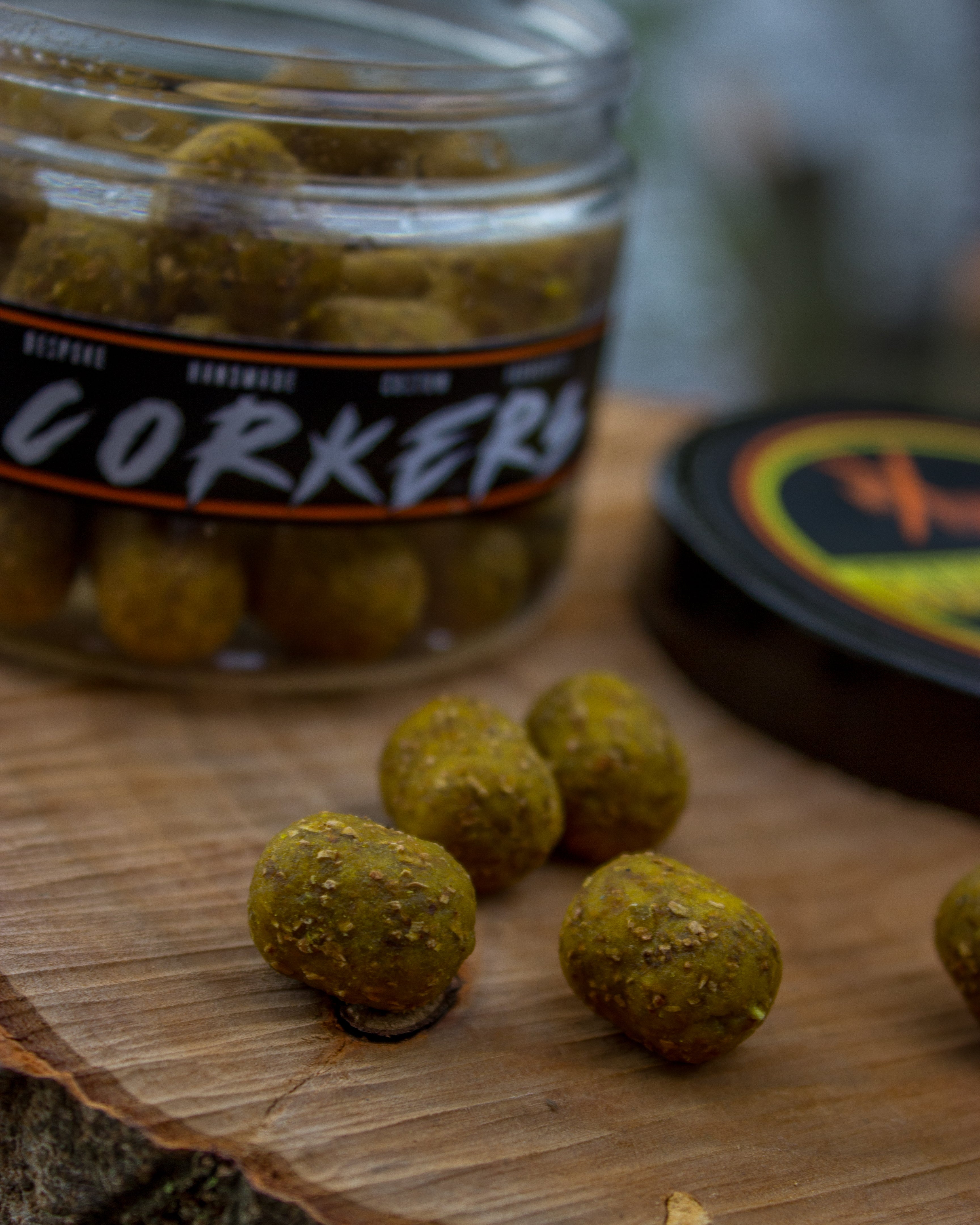 Jar of corker boilies on a wooden surface with a blurred background